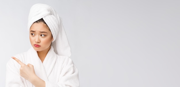 Młoda Piękna Kobieta Nosi Ręcznik Pod Prysznic Po Kąpieli Na Odosobnionym Białym Tle, Wskazując Palcem