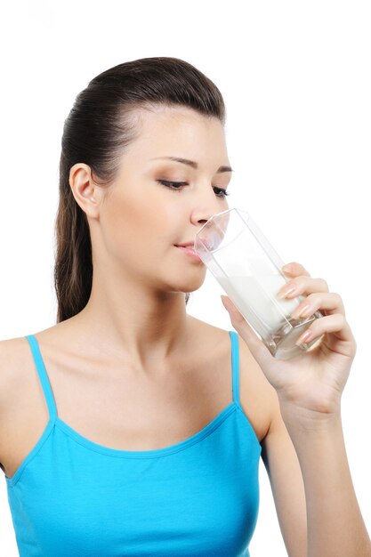 Młoda piękna kobieta pije mleko - na białym tle