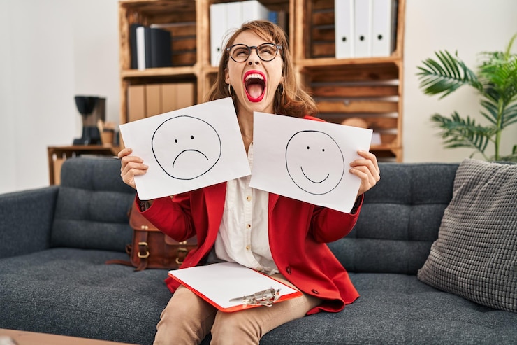 Bezpłatny plik Zdjęcie młoda piękna kobieta pracująca nad depresją, trzymająca papier smutny do szczęśliwych emocji, wściekły i szalony, krzyczący sfrustrowany i wściekły, krzyczący ze złością patrząc w górę.