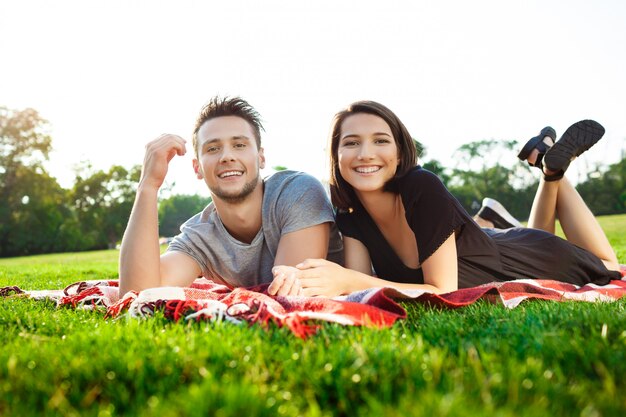 Młoda piękna para ono uśmiecha się, odpoczywający na pinkinie w parku.