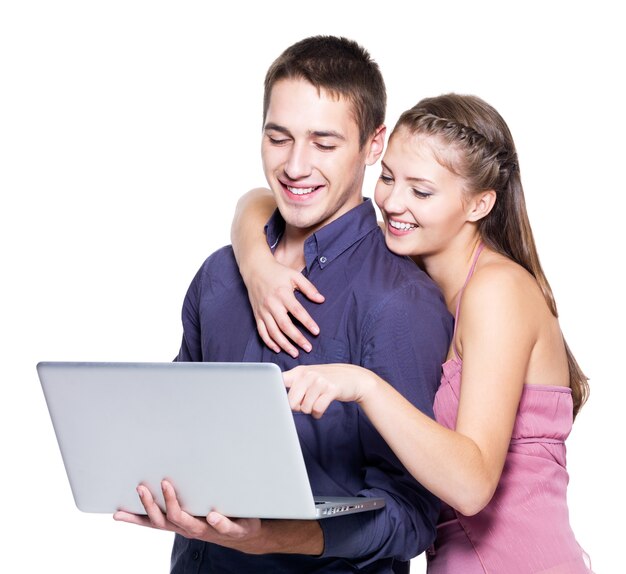 Młoda piękna uśmiechnięta para patrząc na laptopa - na białym tle