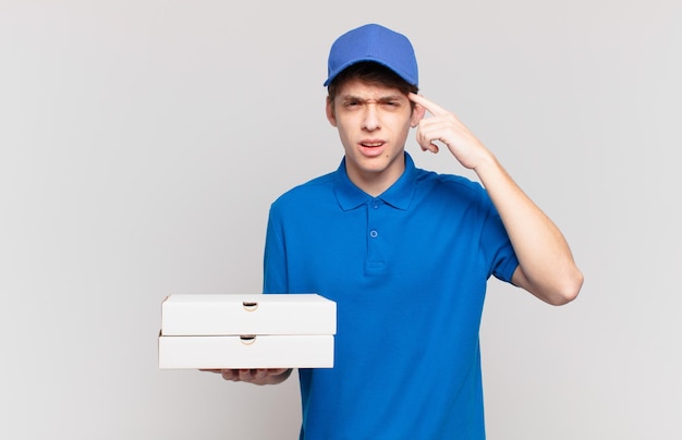 Młoda pizza dostarcza chłopca, który czuje się zdezorientowany i zdezorientowany, pokazując, że jesteś szalony, szalony lub oszalały