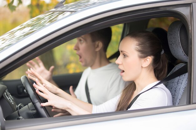 Młoda przestraszona kobieta kierowcy i mężczyzny