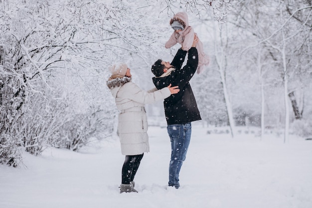 Młoda rodzina z małą córeczką w lesie zimą pełną śniegu