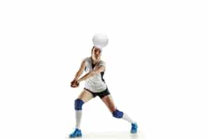 Bezpłatne zdjęcie młoda siatkarka na białym tle na tle białego studia. kobieta w sportowym sprzęcie i butach lub trampkach, trenuje i ćwiczy. pojęcie sportu, zdrowego stylu życia, ruchu i ruchu.