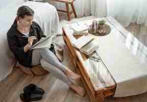 Bezpłatne zdjęcie młoda studentka odrabia zadania w domu, siedząc z notatnikiem w rękach.