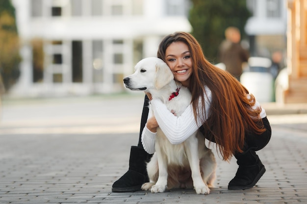 młoda szczęśliwa kobieta z psem na zewnątrz