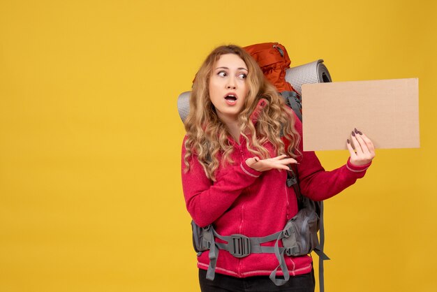 Młoda zszokowana podróżująca dziewczyna zbierająca swój bagaż pokazująca wolne miejsce do pisania