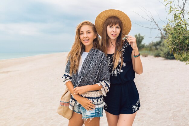 Młode hipster piękne kobiety na wakacjach na tropikalnej plaży, stylowy letni strój, uśmiechnięty szczęśliwy, trend w modzie, czarno-biały styl hippie, modne akcesoria, przyjaciółki bawiące się razem