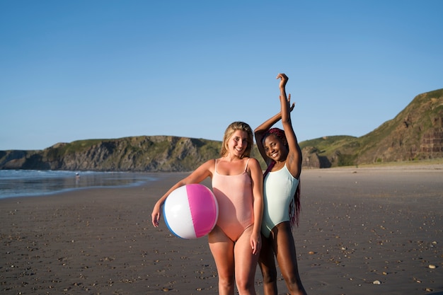 Bezpłatne zdjęcie młode kobiety bawią się na plaży