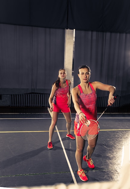 Bezpłatne zdjęcie młode kobiety bawić się badminton przy gym