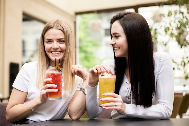 Bezpłatne zdjęcie młode kobiety cieszą się koktajlami