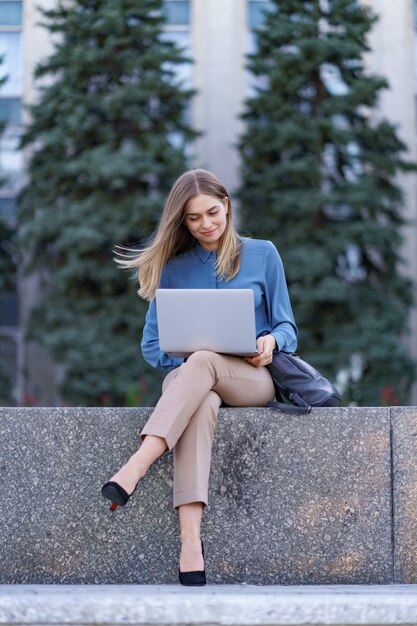 Młode kobiety pracują na laptopie na placu miasta