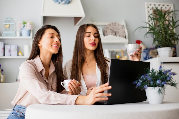 Młode kobiety pracuje na laptopie w domu