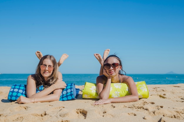 Bezpłatne zdjęcie młode kobiety uśmiechają się do plaży