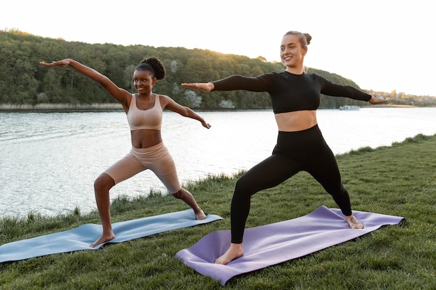 Bezpłatne zdjęcie młode kobiety wspólnie uprawiają fitness na świeżym powietrzu