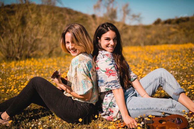 Młode kobiety z ukuleles w polu