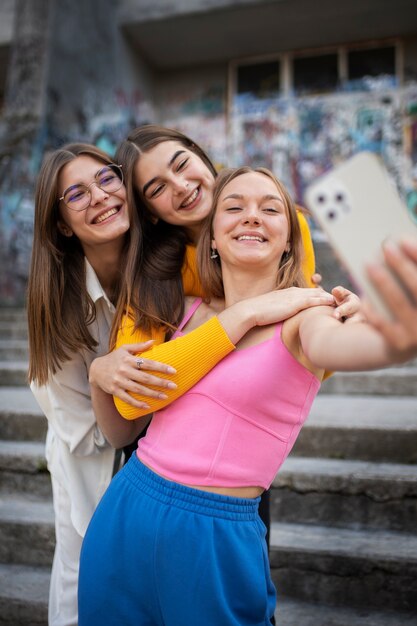 Młode nastolatki nagrywają swoje rolki na zewnątrz w mediach społecznościowych