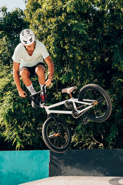 Bezpłatne zdjęcie młodego człowieka doskakiwanie z bmx roweru zawodem bez szans