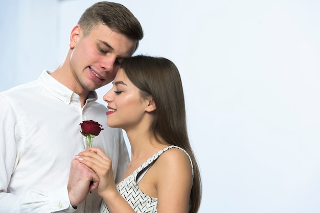 Młodego człowieka przytulenia kobieta z czerwieni różą
