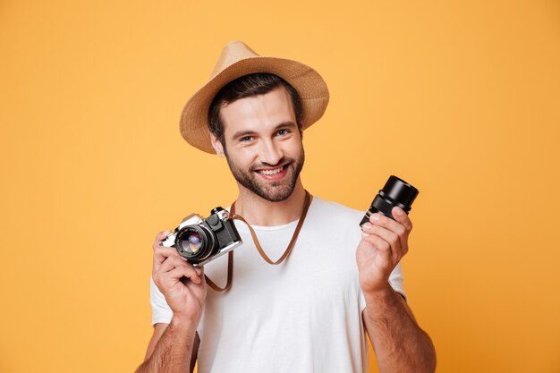 Młodego uśmiechniętego mężczyzna przyglądająca kamera podczas gdy trzymający obiektyw