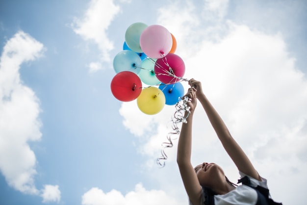 Bezpłatne zdjęcie młodej dziewczyny ręka trzyma kolorowych balony