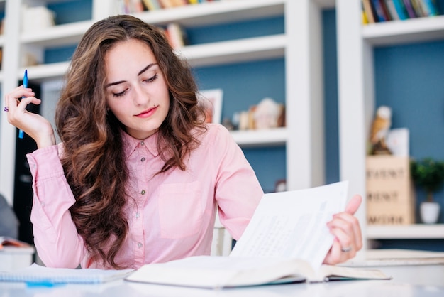 Bezpłatne zdjęcie młodej kobiety studiowanie w bibliotece