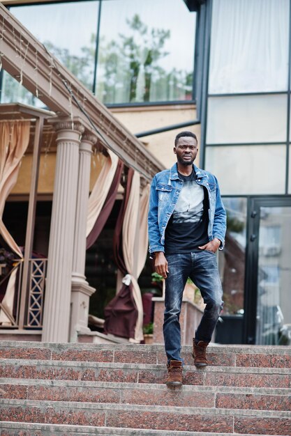 Młody atrakcyjny poważny afroamerykanin model nowoczesny przystojny facet w kurtce dżinsowej stojący na miejskiej ulicy miasta