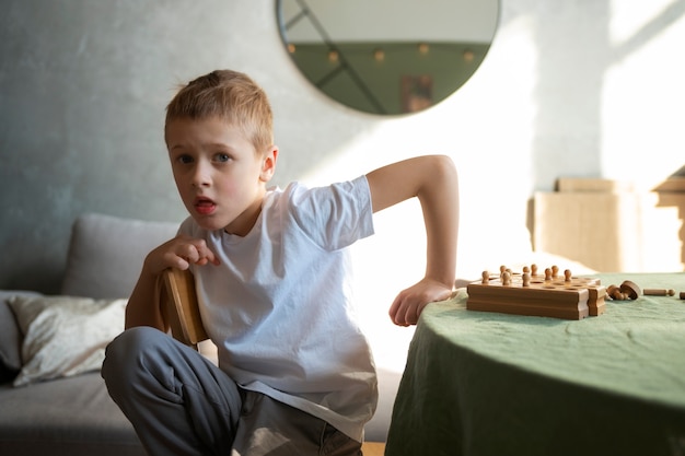 Bezpłatne zdjęcie młody autystyczny chłopiec spędza czas w domu w pomieszczeniu