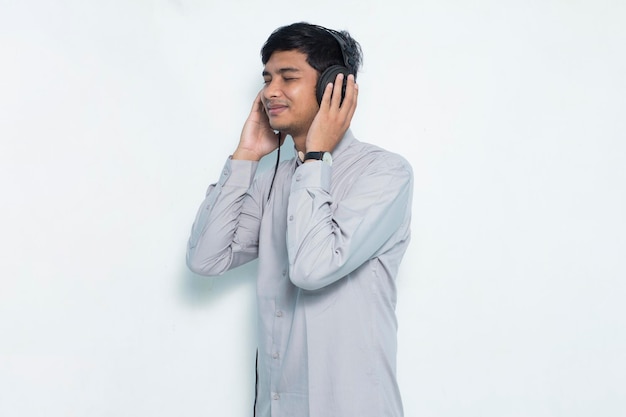 Młody Azjatycki Mężczyzna Słuchający Muzyki W Formalnym Stroju Na Białym Tle Premium Zdjęcia