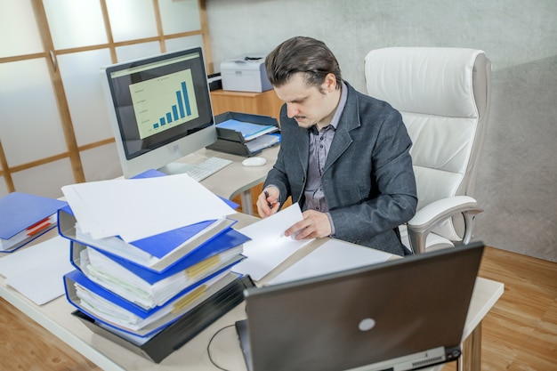 Młody biznesmen pracuje w swoim biurze - pojęcie ciężkiej pracy