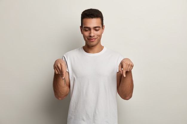 Młody brunet mężczyzna ubrany w białą koszulkę