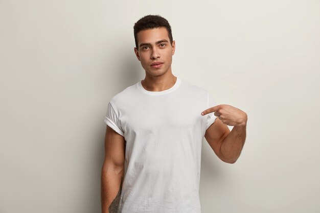 Młody brunet mężczyzna ubrany w białą koszulkę