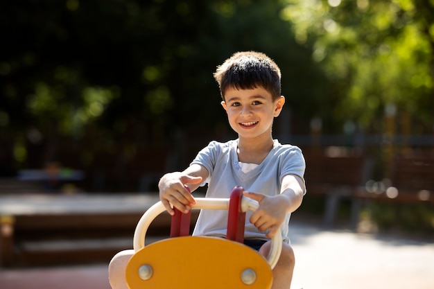 Bezpłatne zdjęcie młody chłopak bawi się na placu zabaw