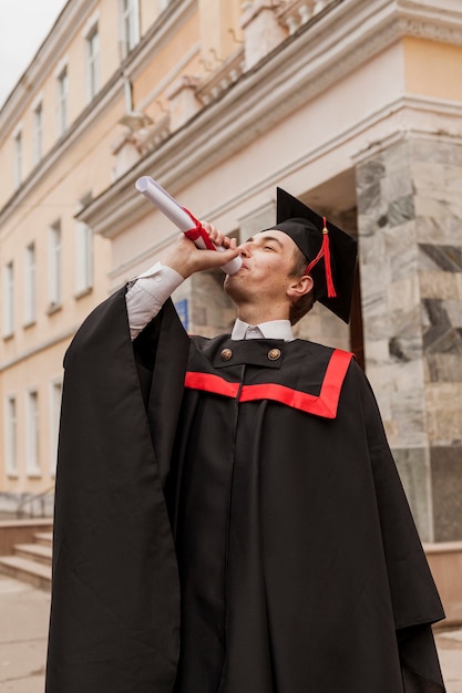 Bezpłatne zdjęcie młody chłopak chętnie kończy studia