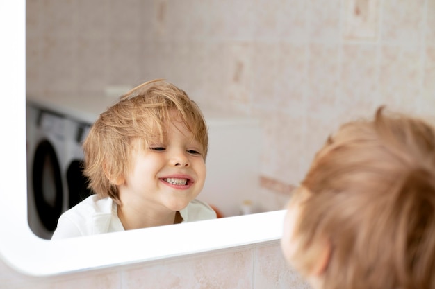 Młody chłopak w łazience patrząc w lustro