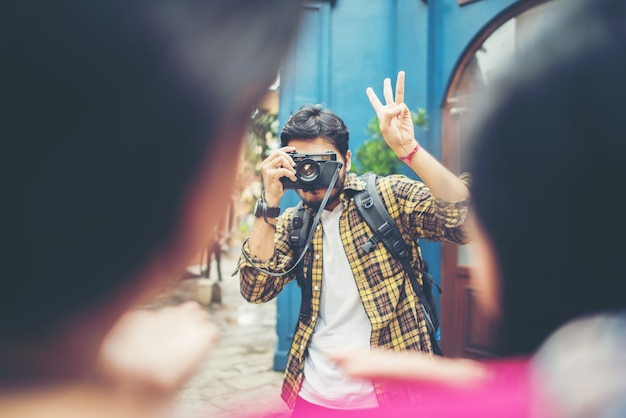 Młody człowiek bierze selfie jego przyjaciele podczas gdy podróżujący w miastowym wpólnie.