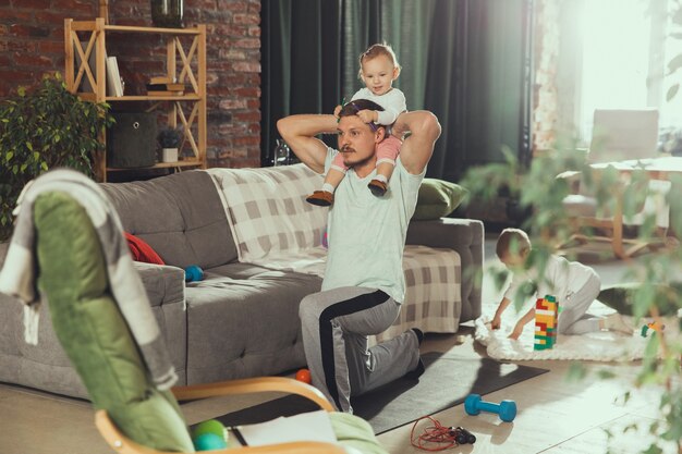 Młody człowiek, ćwiczenia fitness, aerobik, joga w domu, sportowy styl życia.