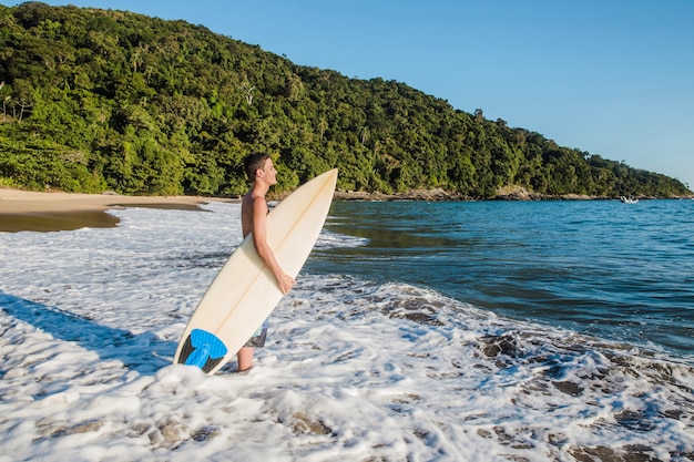 Bezpłatne zdjęcie młody człowiek gotowy do surfingu