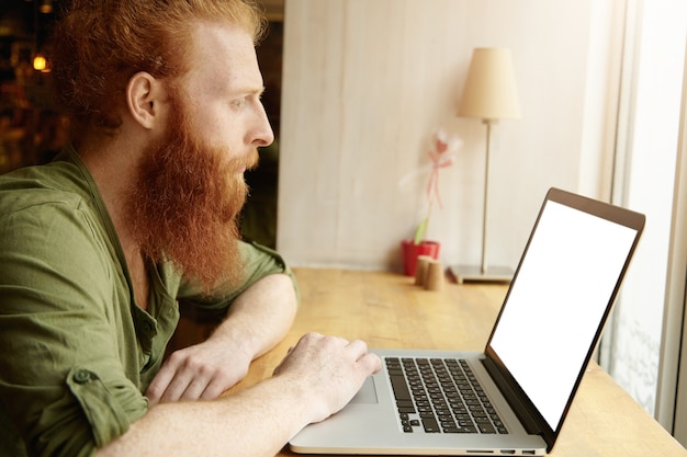 Bezpłatne zdjęcie młody człowiek imbir za pomocą laptopa