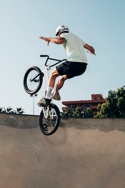 Młody człowiek, jazda na rowerze BMX w skateparku