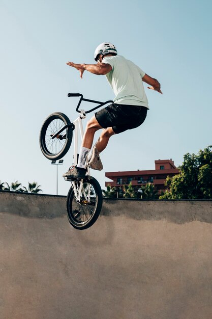Młody człowiek, jazda na rowerze BMX w skateparku