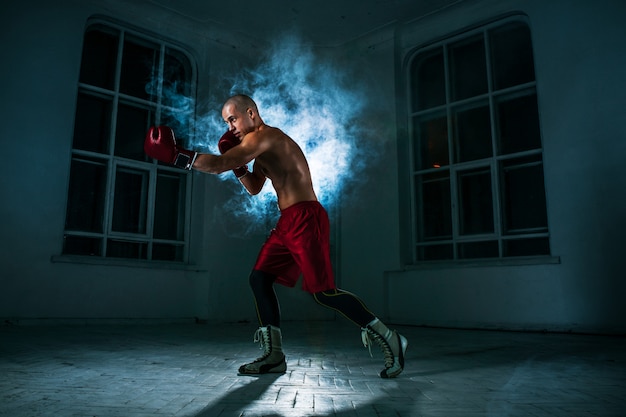 Młody Człowiek Kickboxing W Niebieskim Dymie