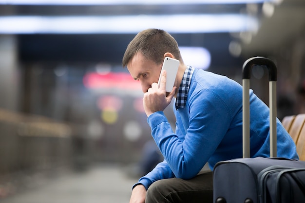 Bezpłatne zdjęcie młody człowiek na telefon w porcie lotniczym