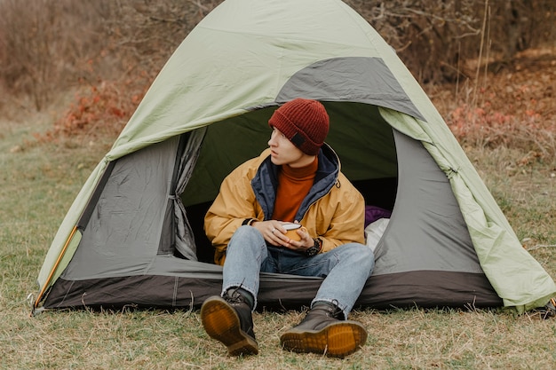 Bezpłatne zdjęcie młody człowiek na zimowej wycieczce z namiotem