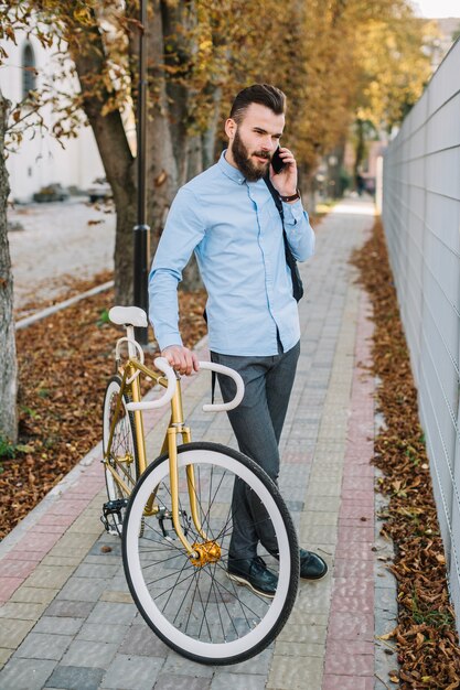 Młody człowiek opowiada na telefonie blisko ono fechtuje się