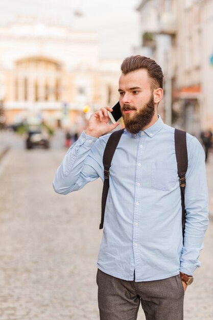 Młody człowiek opowiada na telefonie komórkowym