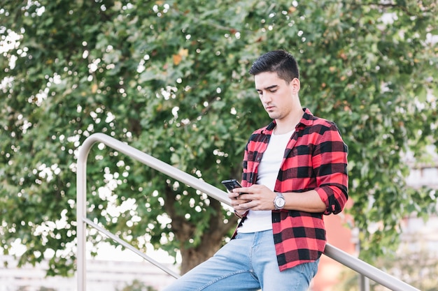 Młody człowiek patrzeje telefon komórkowego ekran
