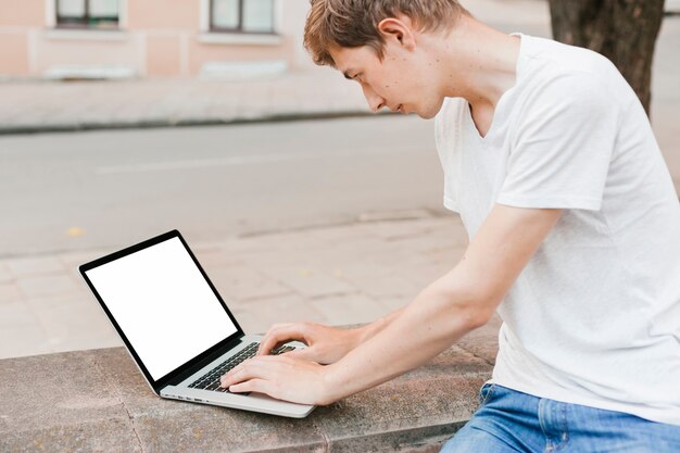 Młody człowiek pracuje na laptopie makieta