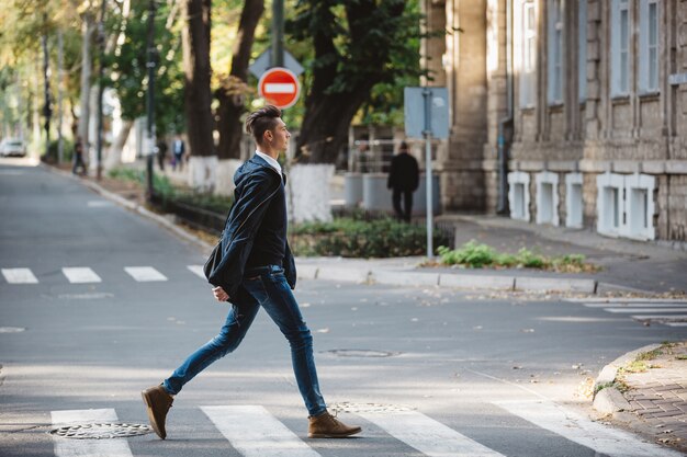 Młody człowiek przechodzi przez ulicę
